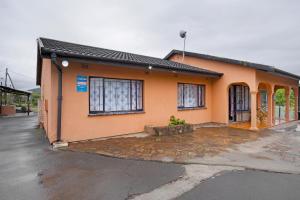 a small orange house with a lot of windows at 25 Jacaranda Lodge & Backpackers in Pinetown
