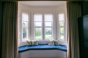 a window seat in a room with pillows on it at Hartsfield Manor in Dorking