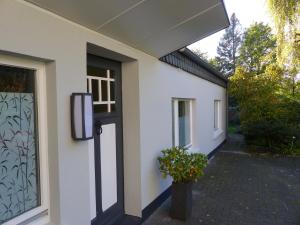 a white building with a door and a potted plant at Prinz Ole in Haan