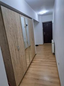 an empty room with wooden doors and a hallway at Relax 2 Central Apartment in Bacău