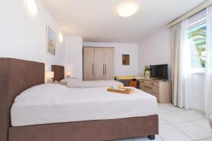 pokój hotelowy z 2 łóżkami i telewizorem w obiekcie Apartments Antares w miejscowości Mali Lošinj