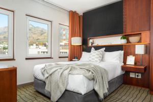 a bedroom with a large bed and two windows at Neighbourgood East City in Cape Town
