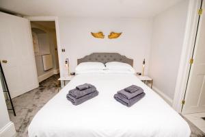 1 dormitorio con 1 cama blanca y 2 toallas en Spacious 2 bed city centre apartment with parking, en Norwich