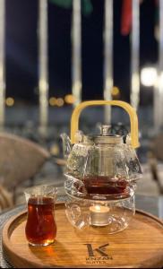 eine Teekanne und eine Tasse Tee auf einem Tablett aus Holz in der Unterkunft اجنحه كنزان in Al Mubarraz