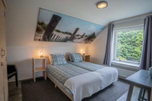 1 dormitorio con cama y ventana grande en De Ruige Hoogte, en De Koog