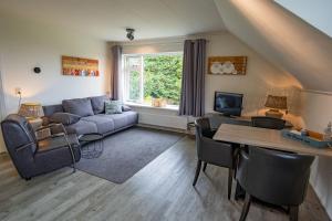 uma sala de estar com um sofá e uma mesa em De Ruige Hoogte em De Koog