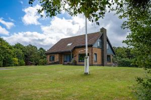 a brick house with a pole in the yard at De Ruige Hoogte in De Koog