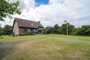 uma casa com uma bandeira em frente a um quintal em De Ruige Hoogte em De Koog