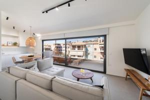 sala de estar con sofá y ventana grande en Pnoe - Feel at Home, en Lefkada