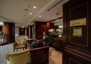 a woman sitting at a desk in a hotel lobby at Dusit Thani Dubai in Dubai +199 photos
