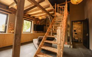 a wooden spiral staircase in a room with a living room at VET - Bed & Breakfast in Beek