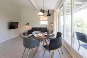 a dining room and living room with a table and chairs at Hello Zeeland - Appartement Beatrixstraat 29 in Domburg