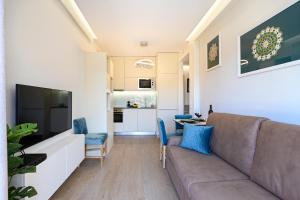 ein Wohnzimmer mit einem Sofa und einem TV in der Unterkunft Lapa City Flat Porto - by Guest SPA in Porto