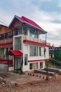 a building with a red roof on top of it at Jot Eco Boutique Stays in Dharamshala