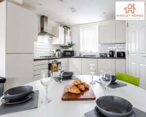 una cocina blanca con una mesa con copas de vino y pan en Modern Townhouse - Free Gated Parking - City Centre - 5 ! By Hinkley Homes Short Lets & Serviced Accommodation en Liverpool