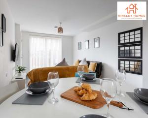 a dining room table with wine glasses and croissants on it at Modern Townhouse - Free Gated Parking - City Centre - 5 ! By Hinkley Homes Short Lets & Serviced Accommodation in Liverpool