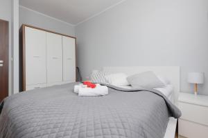 a white bedroom with a gray bed with a mirror at Warsaw Young City Apartment by Renters in Warszawa