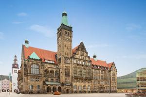 a large building with a clock tower in front of it at Super 8 by Wyndham Chemnitz in Chemnitz