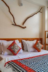 a bedroom with a bed with pillows on it at Jot Eco Boutique Stays in Dharamshala