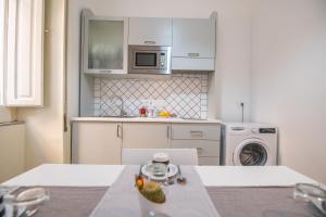 cocina con armarios blancos, lavadora y secadora en Bed&Breakfast Salerno, en Salerno