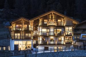 a large building with a sign on it at night at Villa Solinda App Rossini in Selva di Val Gardena