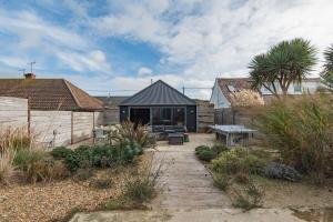 ein Haus mit einer Terrasse und einem Tisch in der Unterkunft Lark Rise by Bloom Stays in Camber