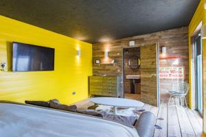 Zimmer mit gelber Wand, Tisch und TV in der Unterkunft Lark Rise by Bloom Stays in Camber