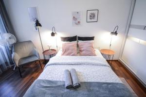 a bedroom with a bed with two pillows on it at LION apartments - LaBA in Krakow