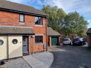 a brick house with cars parked in the driveway at Pass the Keys Homely and central with parking in Exeter