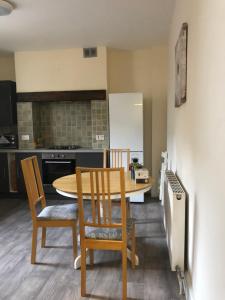 a kitchen with a table and chairs and a kitchen with a refrigerator at Comfortable home, town centre, free parking,Multiple Rooms in Cheltenham