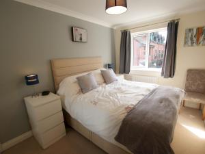 1 dormitorio con 1 cama con sábanas blancas y ventana en Pass the Keys Homely and central with parking en Exeter