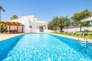 een villa met een zwembad en een huis bij Villa Valentina by Algarve Vacation in Almancil