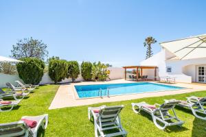 una piscina con tumbonas y una piscina en Villa Valentina by Algarve Vacation, en Almancil
