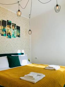 a bedroom with a yellow bed with towels on it at Joseph Hayn Apartments in Sighişoara