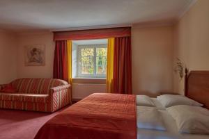 1 dormitorio con 1 cama, 1 silla y 1 ventana en Hotel Donauhof, en Deggendorf