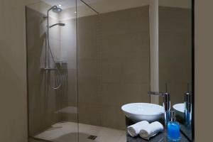 a bathroom with a shower with a sink and a toilet at Hotel Donauhof in Deggendorf