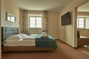 a bedroom with a bed and a television in it at Hotel Donauhof in Deggendorf