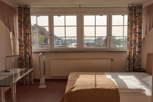 a bedroom with a bed and a large window at Hotel Donauhof in Deggendorf