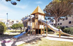 a playground with a slide in front of a building at Stunning Apartment In Le Barcars With Kitchen in Le Barcarès