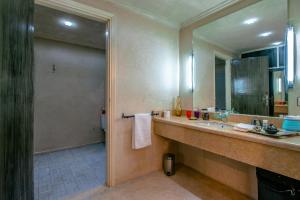 uma casa de banho com um lavatório e um espelho grande em Prestige du Souss em Oulad Barrehil