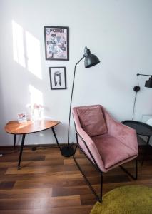 uma sala de estar com uma mesa, uma cadeira e um candeeiro em LION apartments - LaBA em Cracóvia