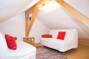 巴德伊舍的住宿－Ferienhaus Salzkammergut，阁楼间配有2张白色沙发和红色枕头