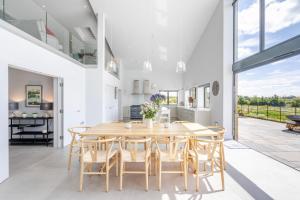 a kitchen and dining room with a wooden table and chairs at The Grove - Converted Cattle Barn in Malmesbury