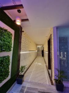 um corredor de um edifício com plantas nas paredes em Hotel Shanti Grand Inn em Gorakhpur