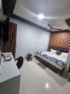 um quarto com uma cama e uma secretária com um monitor em Hotel Shanti Grand Inn em Gorakhpur