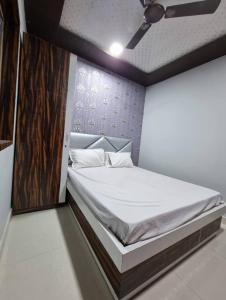a bedroom with a large bed with a white bedsheet at Hotel Shanti Grand Inn in Gorakhpur