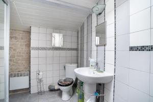 Baño blanco con aseo y lavamanos en Maison d'une chambre avec jardin amenage et wifi a La Bretonniere la Claye, 