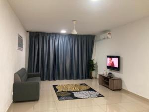 uma sala de estar com um sofá e uma televisão e uma cortina em ABSYAR HOMESTAY SELASIH em Putrajaya