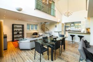 a living room with a dining table and a kitchen at Unique 2 Bedroom converted Artists Studio in London