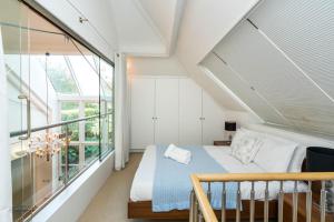 ein Schlafzimmer mit einem Bett und einem großen Fenster in der Unterkunft Unique 2 Bedroom converted Artists Studio in London